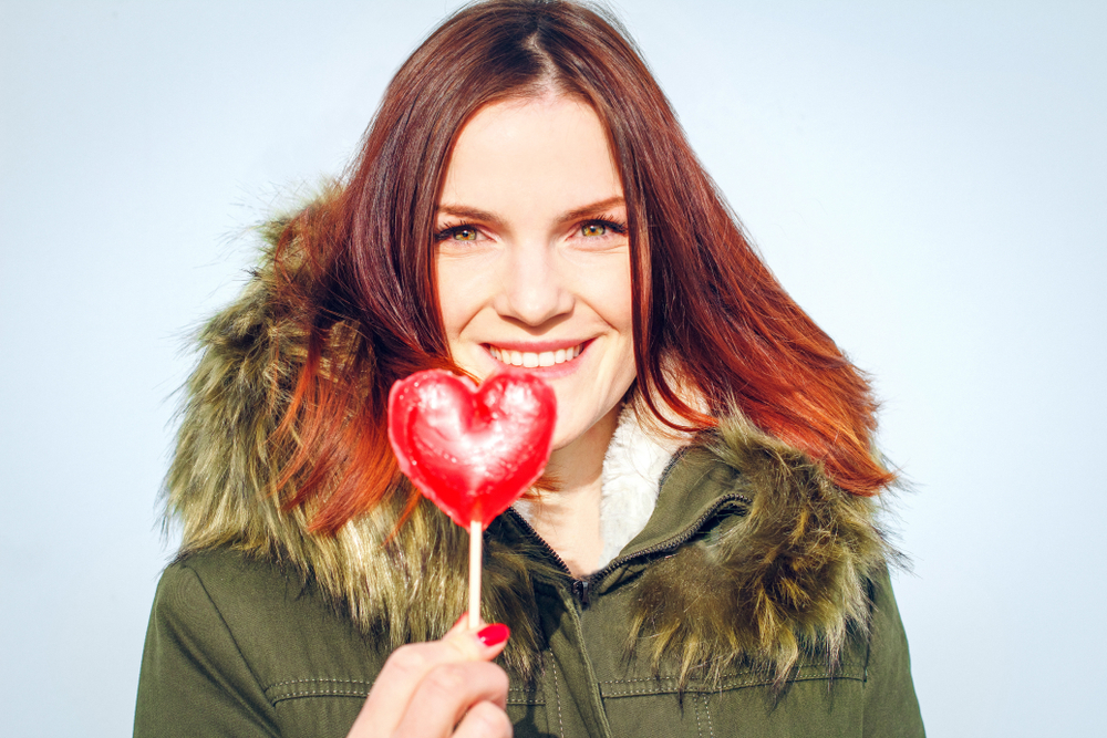 Woman holding a heart balloon in an article by Caroline Maguire on how to feel comfortable in your own skin.