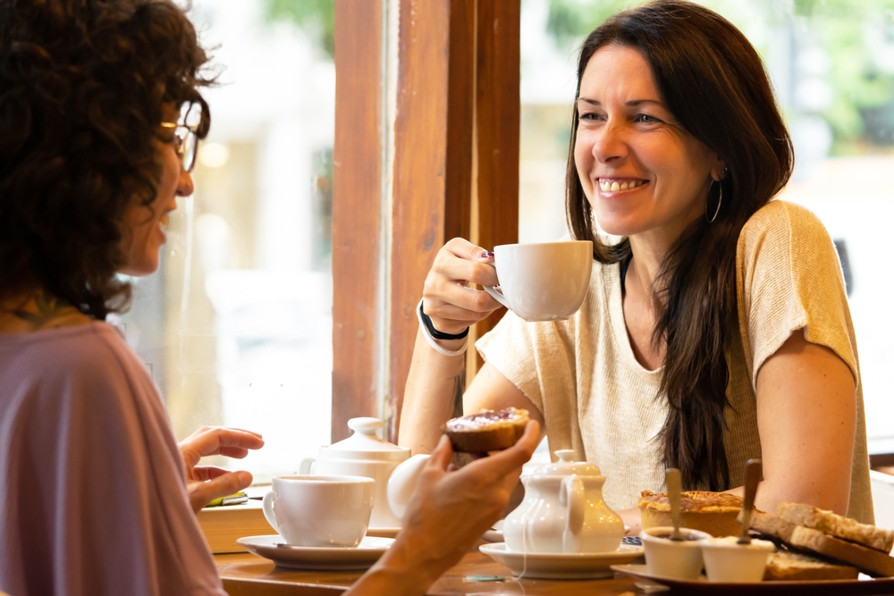 Two women having coffee in an article by caroline maguire on women with adhd and friendship